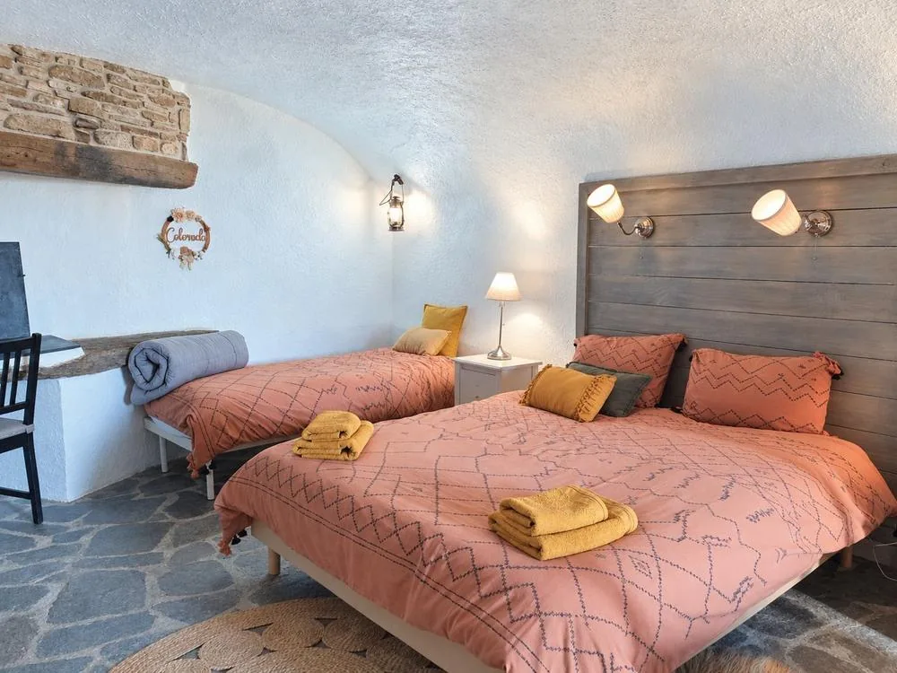 Chambre voûtée dans la roche, lits et linge ocre